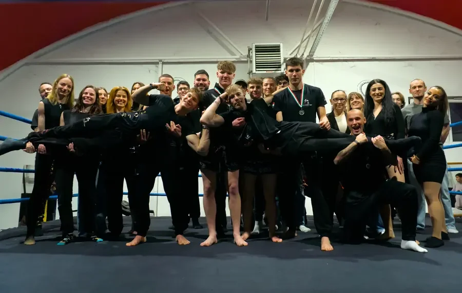 The Kiss Fighting Academy team posing together in the boxing ring.